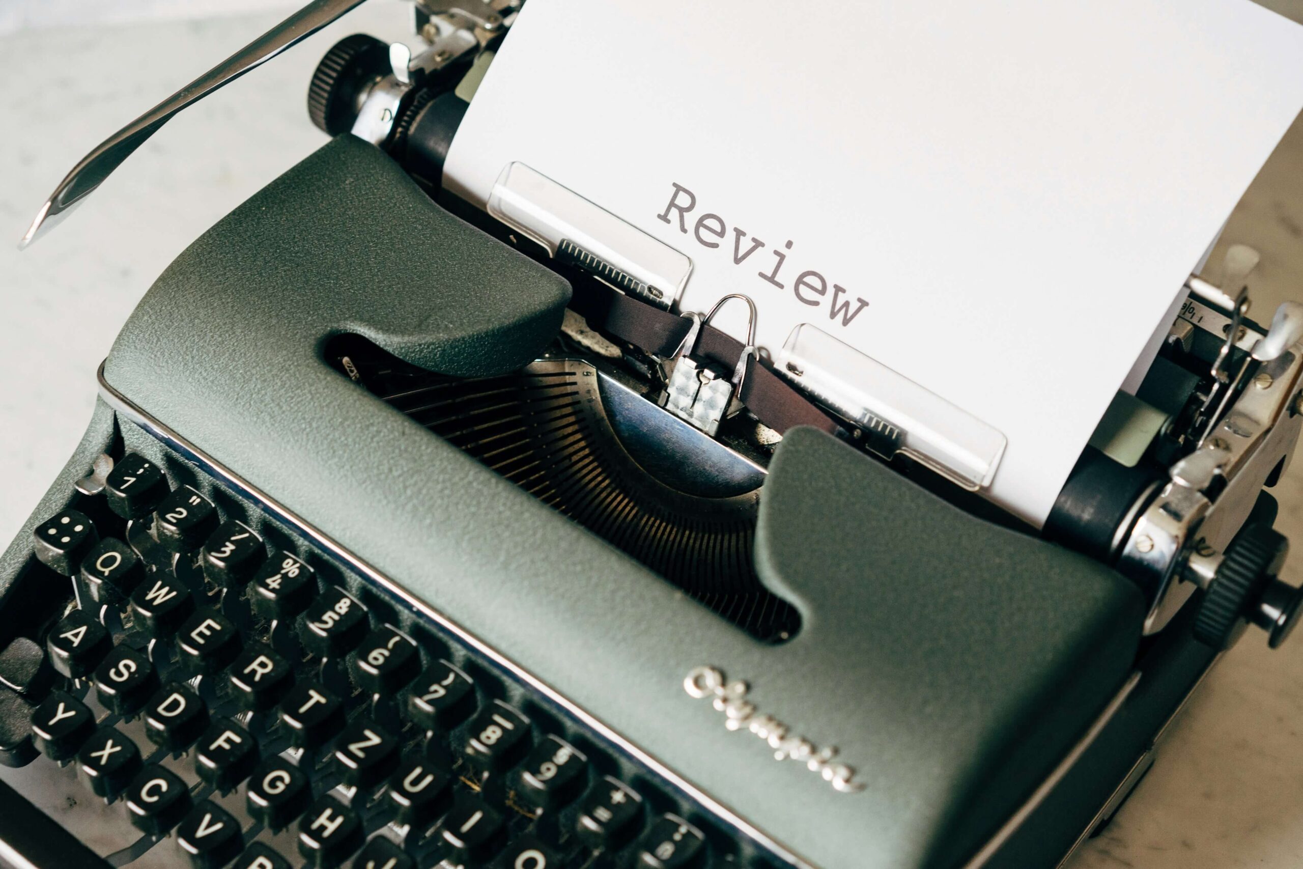 Black typewriter with the word Review typed on the paper